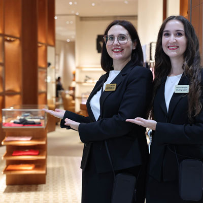 Due personal shopper professionali in uniforme nera in un negozio di lusso