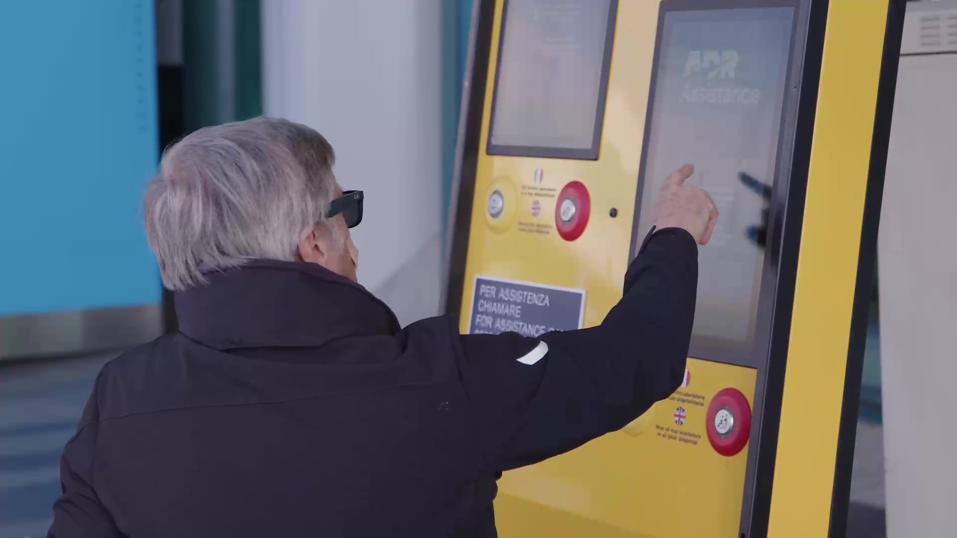Persona che interagisce con chiosco di contatto in aeroporto - Punti di contatto e richiesta assistenza